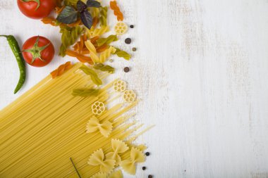 Pişmemiş makarna ve baharat ahşap bir masa üzerinde