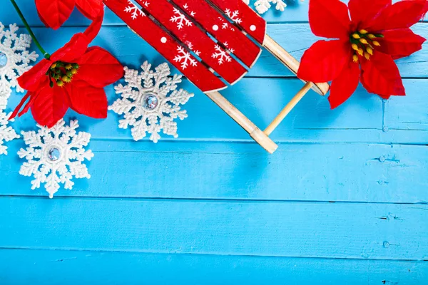 Natal Ainda Vida Sleds Flocos Neve Poinsettia Fundo Madeira Azul — Fotografia de Stock