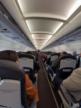 Uçağın kabini uçuşta. Uçaktaki yolcular.