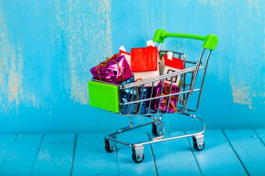 İş hayattır. Alışveriş arabasında evler ve hediye kutuları. Emlak almak ya da satmak.