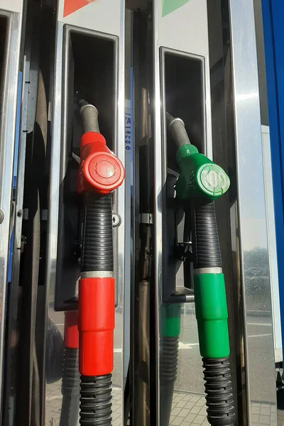 Multicolored fuel pistols on fuel station.