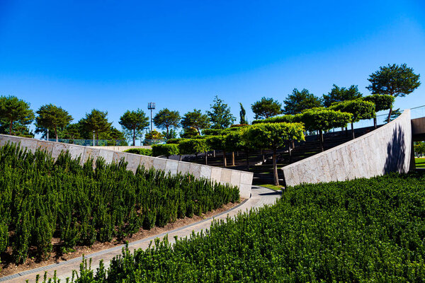 City Park "Krasnodar" or Galitsky Park. Beautiful trees and lawn on terraces of park around football stadium "Krasnodar".  Landscaping. Krasnodar, Russia - July 11, 2020