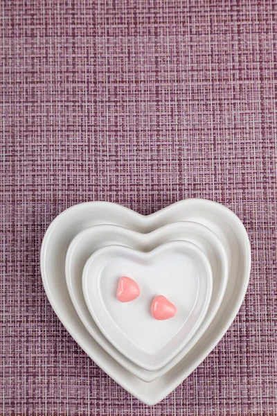Teller Herzform Und Zwei Süßigkeiten Auf Rosa Hintergrund Valentinstag — Stockfoto