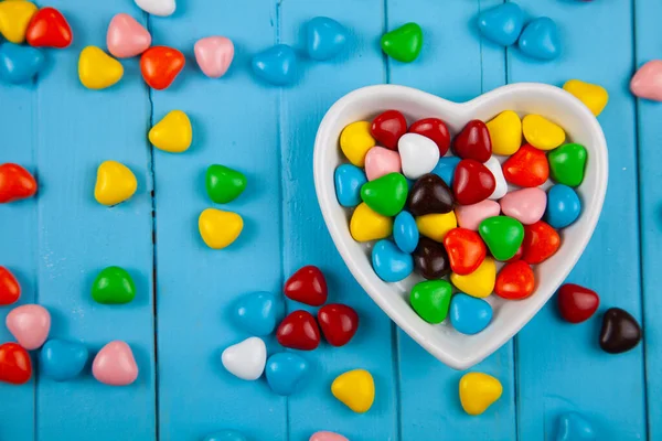 Kolorowe Cukierki Talerzu Kształcie Serca Niebieskim Drewnianym Tle Walentynki — Zdjęcie stockowe