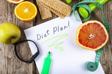 Yararlı ürünler, mezura, spor bilekliği ve ahşap arka planda halterler. Diyet ve sağlıklı yaşam tarzı.