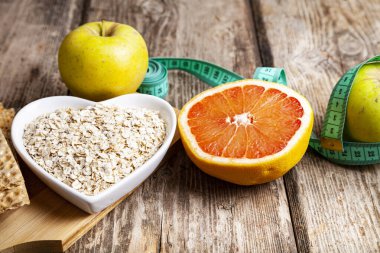 Yararlı ürünler, mezura, yulaf ezmesi ve ahşap arka planda dambıllar. Diyet ve sağlıklı yaşam tarzı.