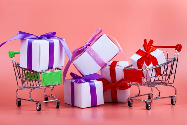 ピンクの背景にショッピングカートやギフト コンセプト 贈り物の購入 — ストック写真