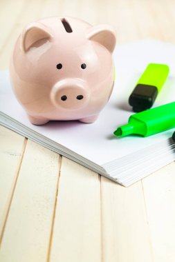 Domuz kumbarası ve kağıt üzerinde işaretler. Tasarruf planı.