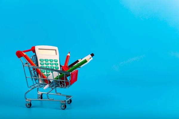 Schreibwaren Und Einkaufswagen Auf Blauem Hintergrund Einkaufen Für Die Schule — Stockfoto