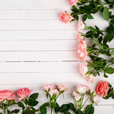 Açık ahşap arka planda pembe güllerin sınırı, metin için yer. Tebrik kartı.