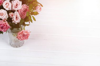 Hafif ahşap arka planda pembe güller. Güzel kart.