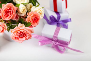 Açık ahşap arka planda hediyeli pembe güller ve kutular..