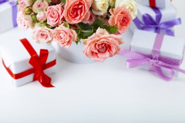 Açık ahşap arka planda hediyeli pembe güller ve kutular..