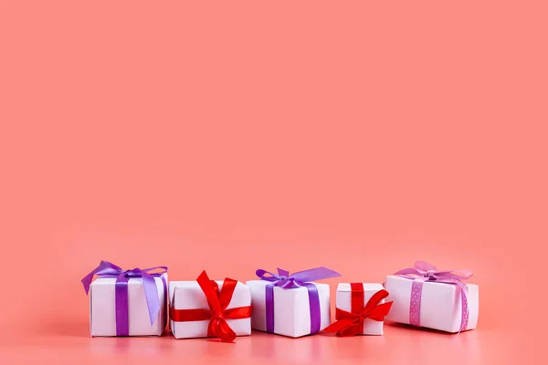 ピンクの背景に明るい弓を持つ白い箱 休日への贈り物 — ストック写真