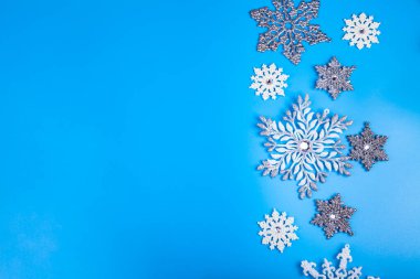 Mavi arka planda kar taneleri. Noel dekoru. Metnin için yer.