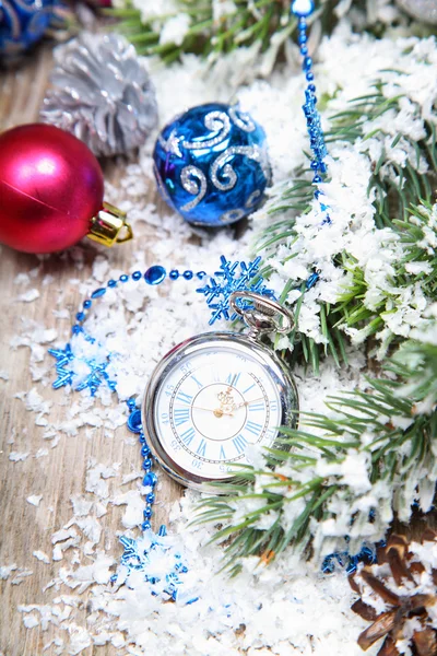 Decoraciones navideñas y reloj en la nieve — Foto de Stock