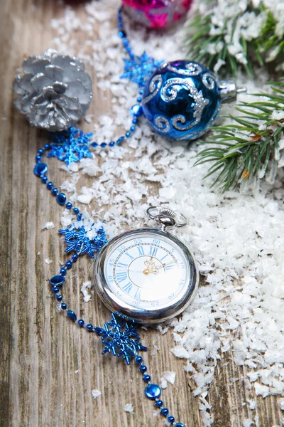 Decoraciones navideñas y reloj en la nieve — Foto de Stock
