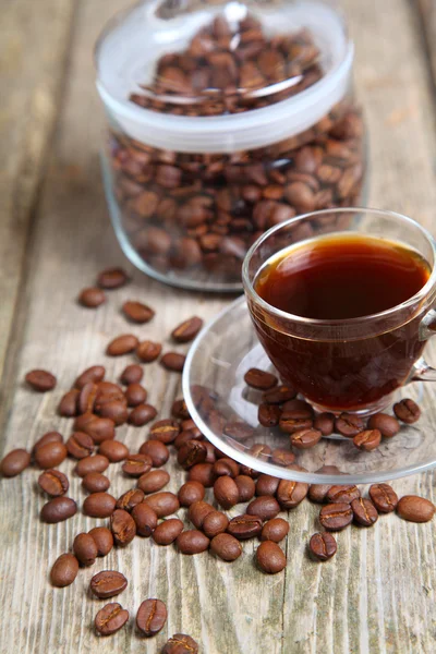 Transparante kopje koffie en koffiebonen met de bank — Stockfoto