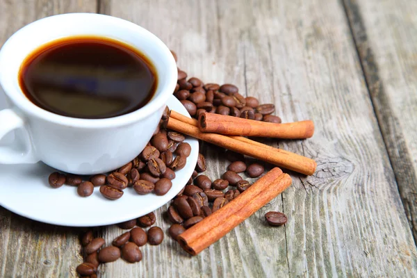 Kopje van koffie, bonen en kaneel stokken — Stockfoto