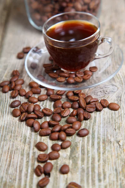 Transparante kopje koffie en koffiebonen met de bank — Stockfoto