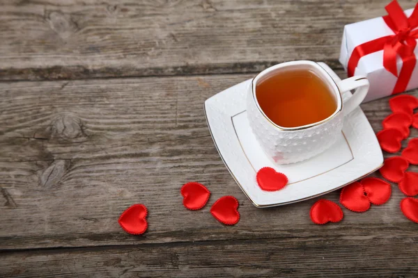 Xícara de chá, bolo e corações vermelhos — Fotografia de Stock