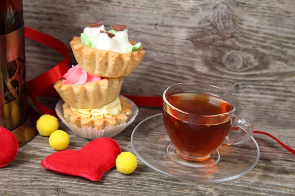 Taza de té, pasteles y corazones rojos — Foto de Stock