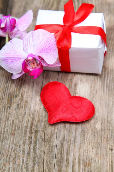 Праздничные подарки, орхидея и красное сердце — стоковое фото