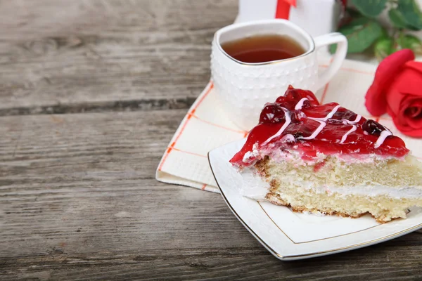 Xícara de chá, pedaço de bolo e rosa vermelha — Fotografia de Stock