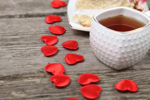 Taza de té, pedazo de pastel y corazón rojo — Foto de Stock