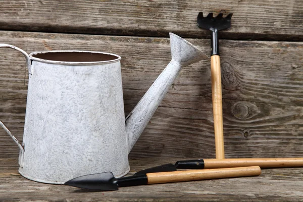 Watering can on a wooden background — Stock Photo, Image