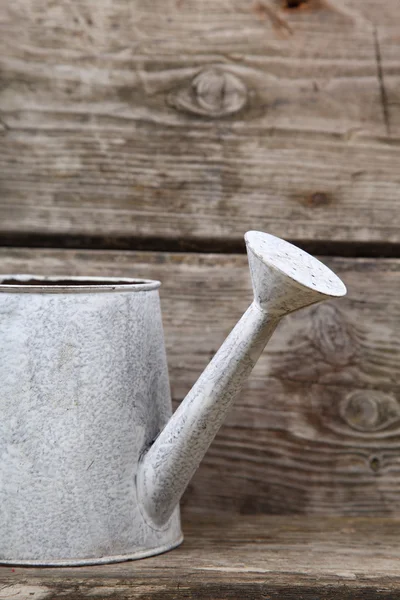 Watering can on a wooden background — Stock Photo, Image