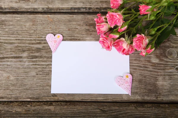 Buquê de rosas rosa, coração e cartão de saudação — Fotografia de Stock