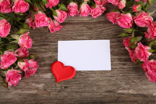 Bukett med rosa rosor, hjärta och gratulationskort — Stockfoto