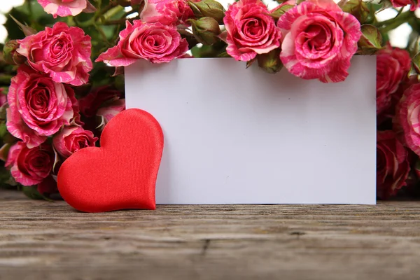 Ramo de rosas rosadas, corazón y tarjeta de felicitación — Foto de Stock