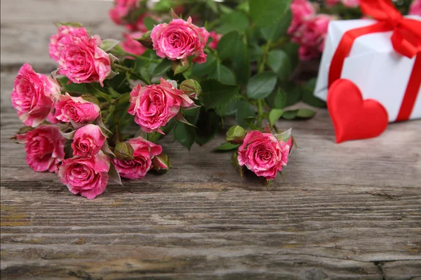 Μπουκέτο με τριαντάφυλλα ροζ, καρδιά και δώρο — Φωτογραφία Αρχείου