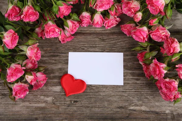 Buquê de rosas rosa, coração e cartão de saudação — Fotografia de Stock