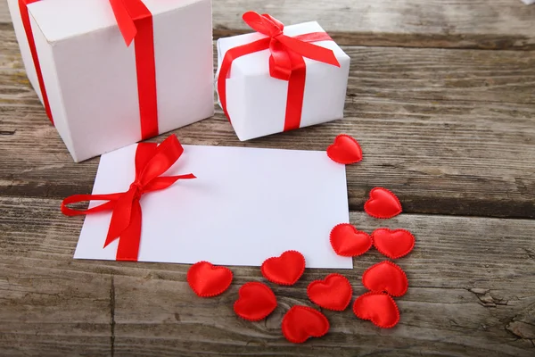 Greeting card with red bow, hearts and gifts — Stock Photo, Image