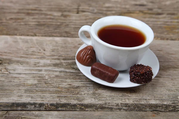 Xícara de chá e chocolates — Fotografia de Stock