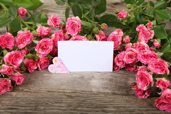 Ramo de rosas rosadas, corazón y tarjeta de felicitación — Foto de Stock