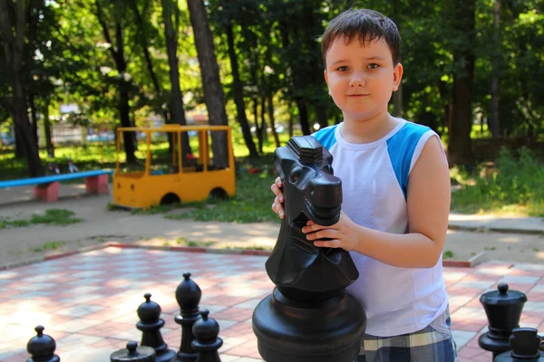 Boy plays in the big chess — Stock Photo, Image