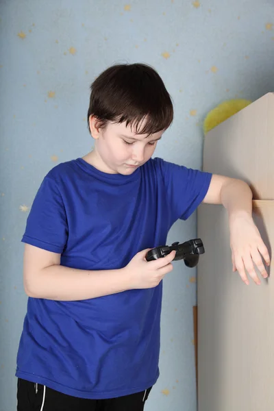 Boy looks at the joystick — Stock Photo, Image