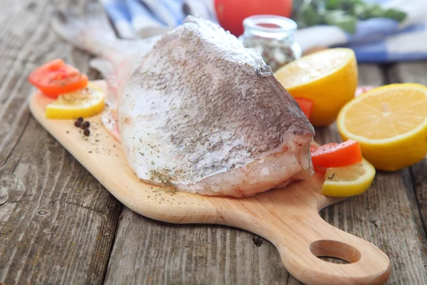 Rå fisk på skärbräda — Stockfoto