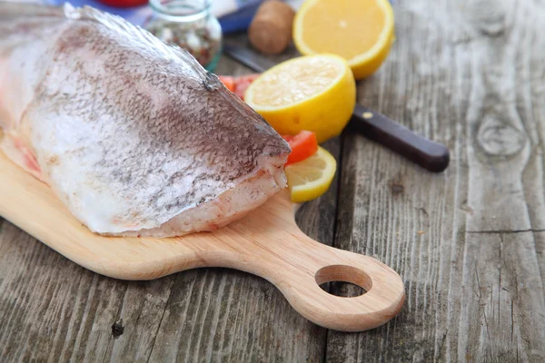 Pescado crudo en una tabla de cortar —  Fotos de Stock