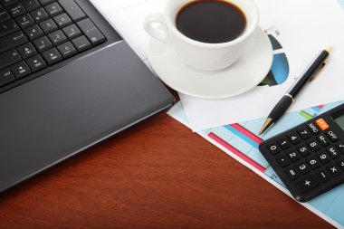 Dizüstü bilgisayar, hesap makinesi, kahve ve buruşuk kağıt bardak 