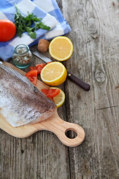 Pescado crudo en una tabla de cortar —  Fotos de Stock