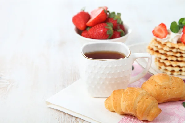 Čaj s croissanty a čerstvé jahody na stůl — Stock fotografie