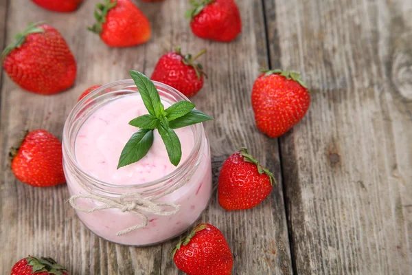 Yogur de fresa y fresa madura en una mesa de madera — Foto de Stock