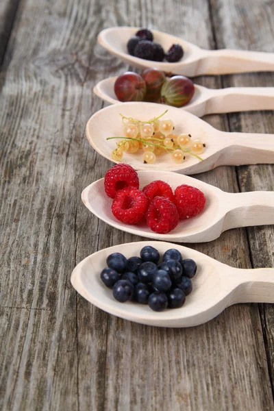 Frutas maduras diferentes em uma colher de madeira — Fotografia de Stock