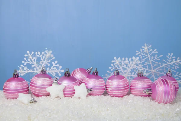 Розовые шарики на снегу — стоковое фото