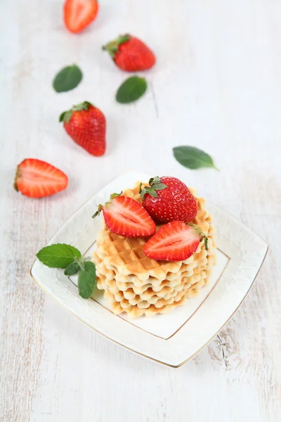 Waffles with strawberries on a wooden table — Stock Photo, Image